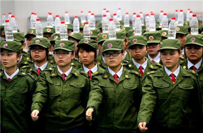 Chinese students standing in military posture with water bottles on their heads (multiple pictures).jpg