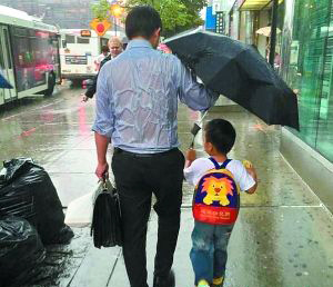 淋雨为孩子撑伞,是暖是傻.jpg