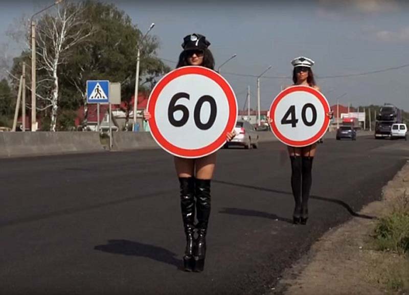 Russia unexpectedly recruits female models with naked breasts to hold up speed limit signs to prevent car accidents.jpg
