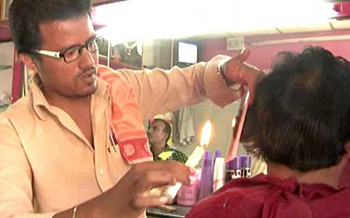 Indian brothers use candles to make haircuts, customers are constantly in flow.jpg