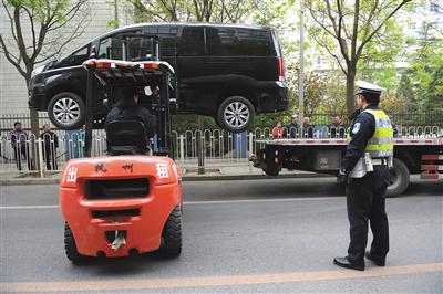 交警在指挥拖车拖走一辆无牌照违停车.jpg