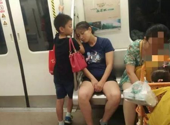 暖心! 男孩地铁里用手为妈妈垫着睡觉!
