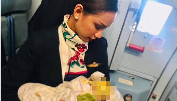 A flight attendant in the Philippines breastfeeds a strange crying baby on a plane .jpg