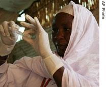 A nurse prepares a polio vaccination for a baby in the Otash refugee camp in South Darfur