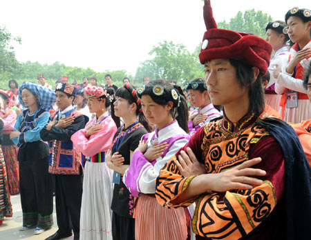 Employees of different ethnic groups mourn during a silent tribute to the people killed in the earthquake, in Beijing, capital of China, May 19, 2008.