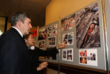 Chinese Ambassadress to Britain Fu Ying (R) shows photos about earthquake in China to British Prime Minister Gordon Brown at the Chinese Embassy in London, capital of Britain, May 20, 2008. Brown came to the Chinese Embassy on May 20 to offer condolences to Chinese quake victims. 